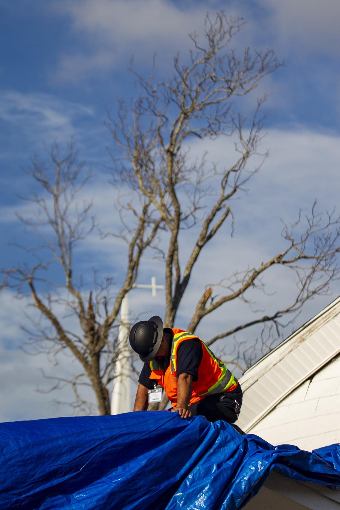 A construction worker repairs a church roof after Hurricane Michael in 2018. SB 180 was intended to help Floridians rebuild after storms. 