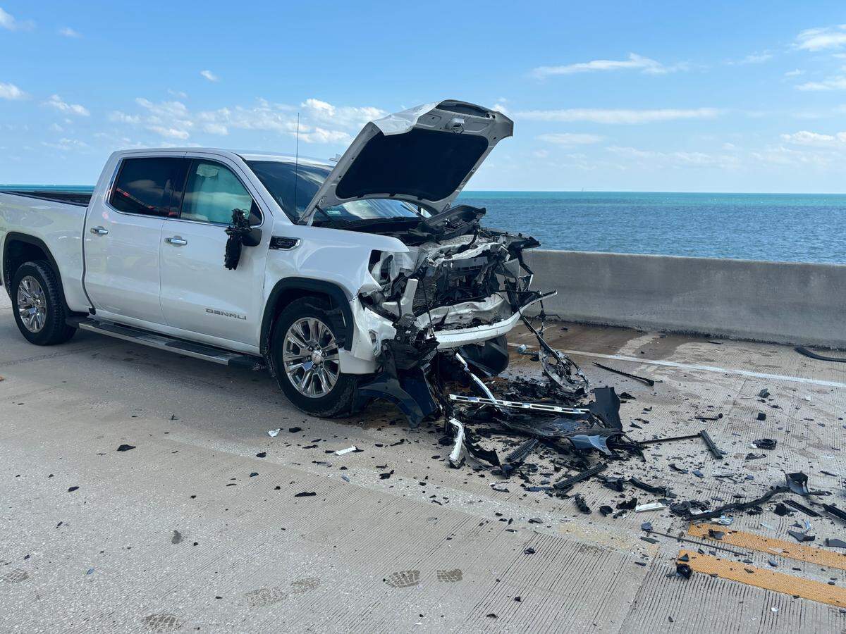 A badly damaged GMC Denali pickup truck is parked on the side of the Seven Mile Bridge in the Florida Keys following a head-on crash with a BMW SUV Monday afternoon, March 3, 2025. Two people in the BMW were flown to Jackson South Medical Center, according to the Monroe County Sheriff’s Office.