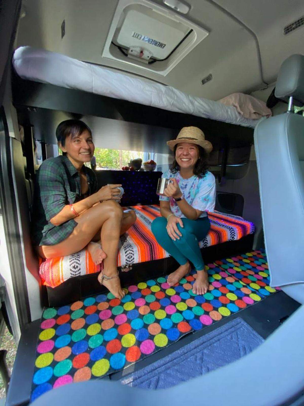 Friends Jojo Lee, right, and Sefora Chavarria relax in one of Ondevan’s newest vans called “Urpi” — the first to include bunk beds — in September.