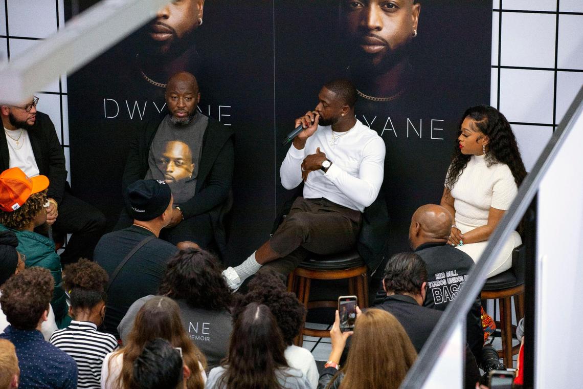 Miami Heat legend Dwyane Wade, center, speaks to an audience during a moderated discussion for his new memoir “Dwyane.” at The Shop Miami in the Wynwood neighborhood of Miami, Florida, on Friday, November 19, 2021.