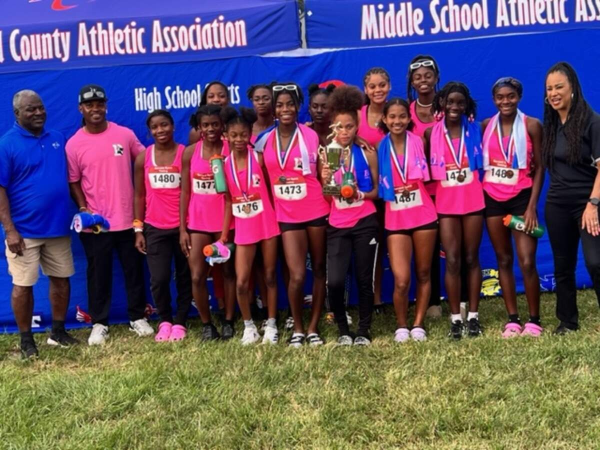 The Dillard girls’ cross-country runners and coaches celebrate after winning the BCAA championship on Thursday afternoon at Markham Park in Sunrise, Fla.