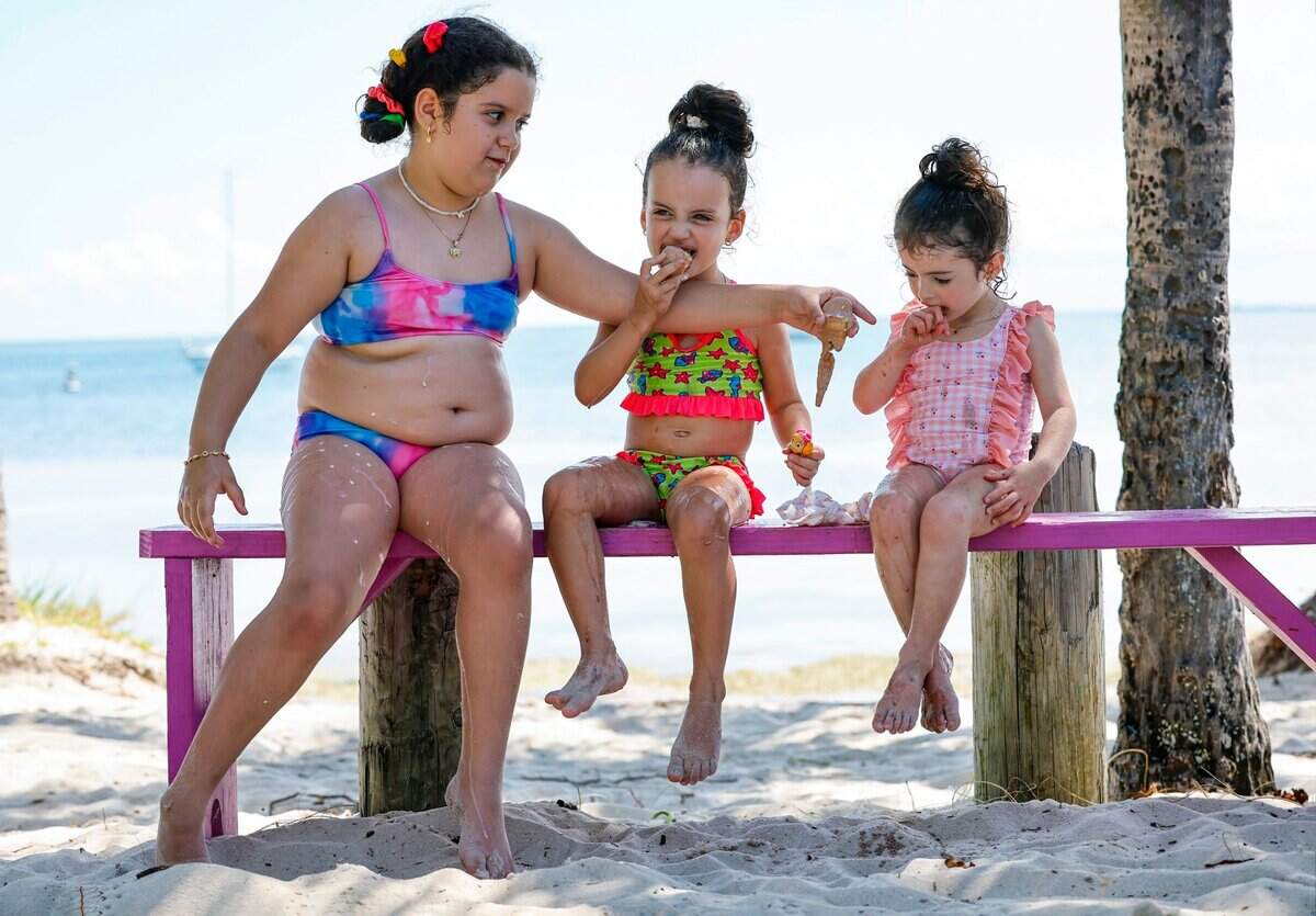 Sisters Nicoele Dones, 8, Lauren Dones, 4, and Diana Dones, 3, of South Miami, eat ice cream on the beaches along Rickenbacker Causeway in Miami, Florida on Thursday, June 6, 2024.