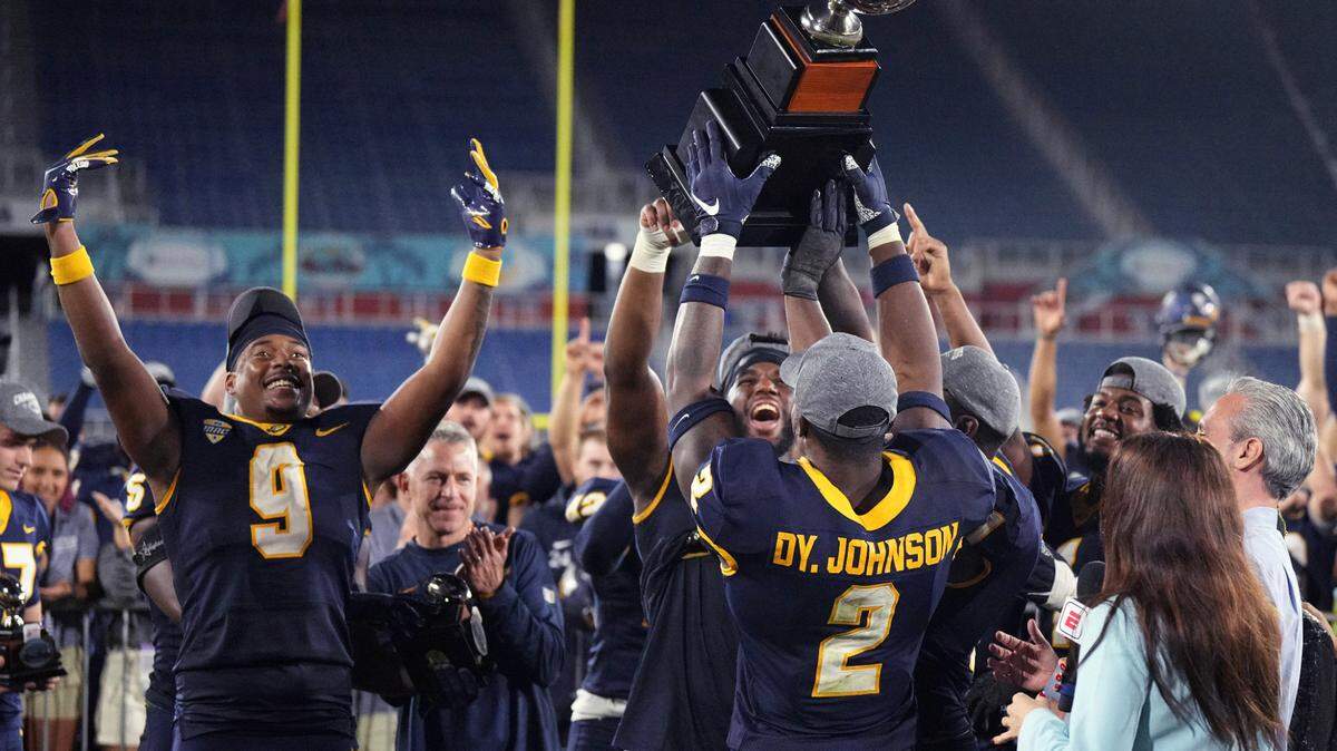 Toledo players hold up the trophy after a win over Liberty in the Boca Raton Bowl NCAA college football game Tuesday, Dec. 20, 2022, in Boca Raton, Fla.