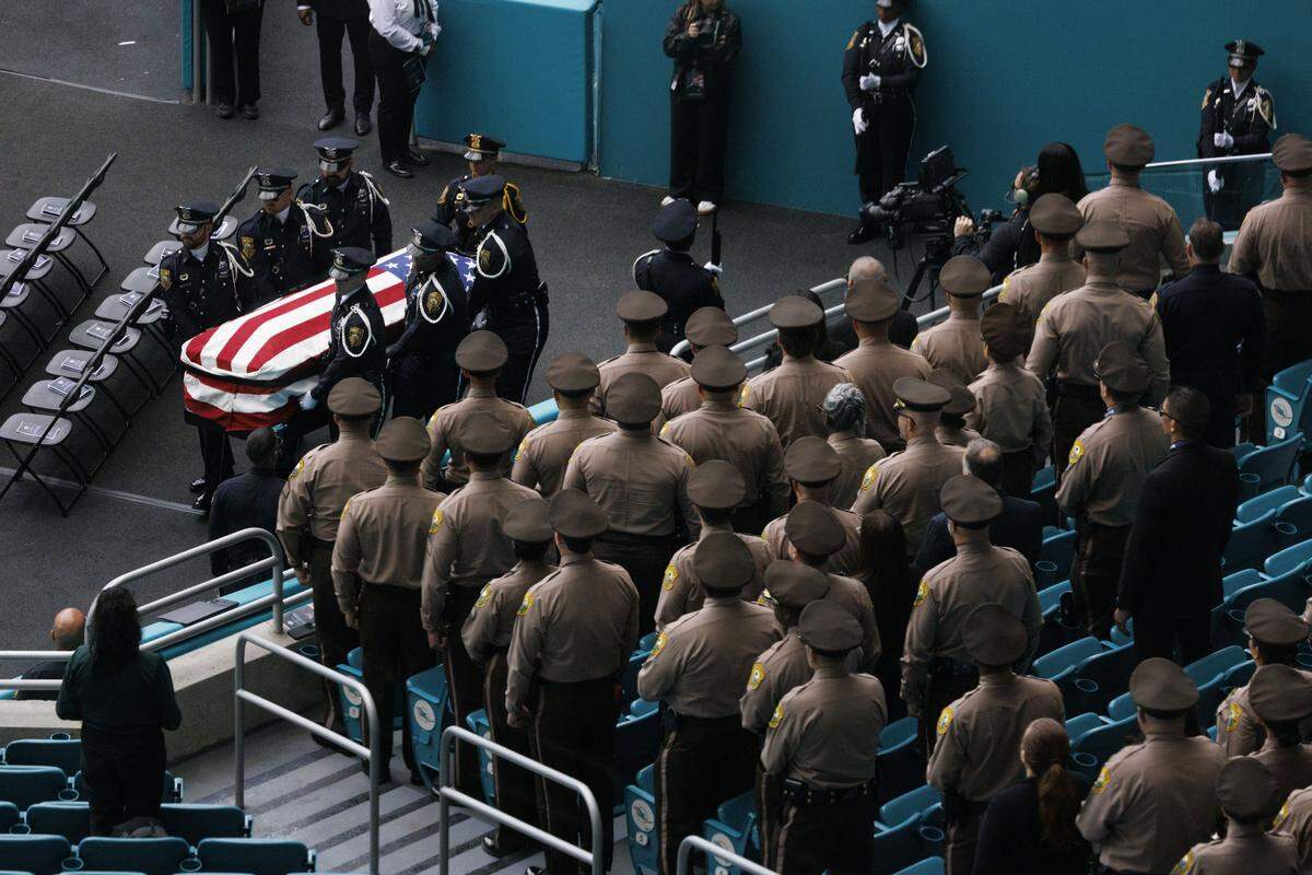 The casket is walked into the service for Miami Beach Police Sergeant David Cajuso on Wednesday, Nov. 12, 2025, at the Hard Rock Stadium in Miami Gardens, Fla.