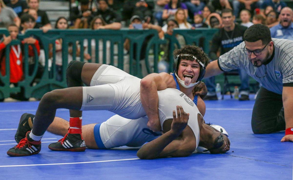 Misha Arbos of South Dade High School reacts as he earns points during a bout against Nicholas Duke of Miami Southridge High School during the GMAC Boys Wrestling Championship held at Ronald Reagan High School on Saturday, February 5, 2022.