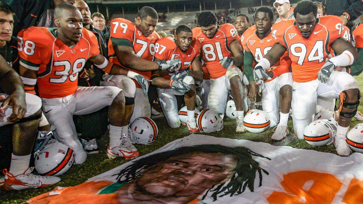 Miami Hurricanes football players, including Rashaun Jones (38) at left, pay their respects around a mural of teammate Bryan Pata after a game against Boston College in Miami on Nov. 23, 2006. Jones was arrested Aug. 19, 2021, in connection with the 2006 fatal shooting of Pata. Pata, 22, was shot and killed outside his Kendall, Fla., apartment the night of Nov. 7, 2006.