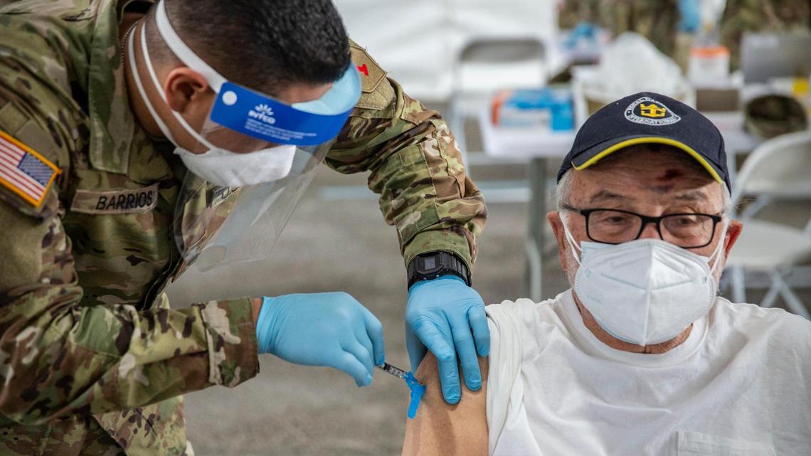  Issac Chanavich, 82, is injected with a COVID-19 vaccine by a U.S. Army medic at a FEMA vaccination site on Wednesday at Miami Dade College’s North Campus.