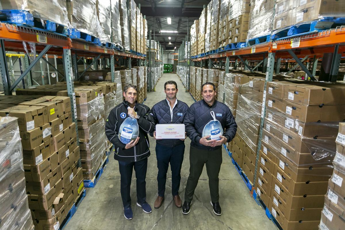 From left to right: Michael Mandich, 36, Nick Mandich, 32, and Mark Mandich, 34, hold some of the food products they keep frozen at their cold-storage warehouse facility in North Miami.
