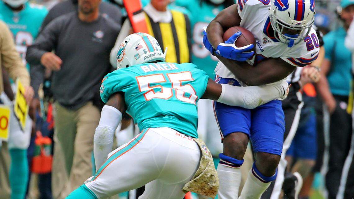 Miami Dolphins linebacker Jerome Baker (55) tries to stop Buffalo Bills Frank Gore (20) in the first quarter at Hard Rock Stadium in Miami Gardens, Florida, Sunday, November, 17, 2019.