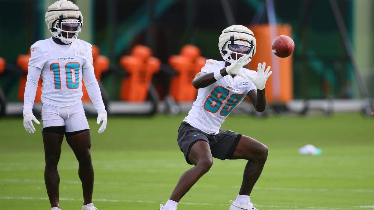 Miami Dolphins wide receiver Grant DuBose (88) catches the football as wide receiver Tyreek Hill (10) watches during training camp at Baptist Health Training Complex in Miami Gardens, Florida, on Monday, September 2, 2024.