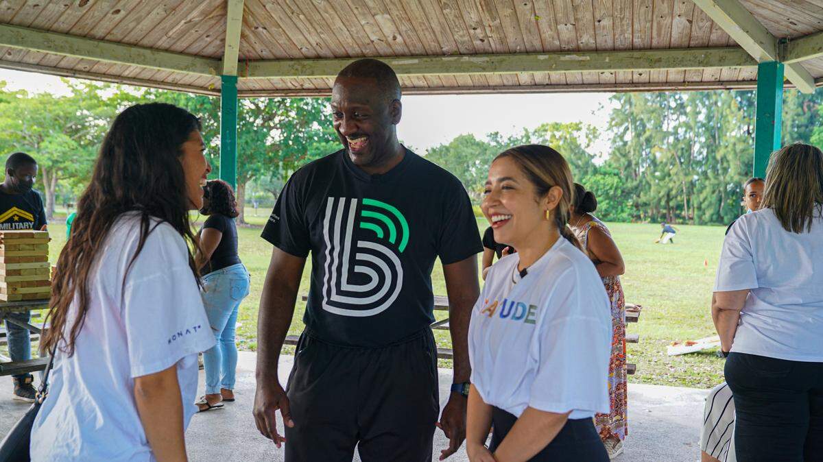 Lu Urdaneta (right) laughs with colleagues at a work function.