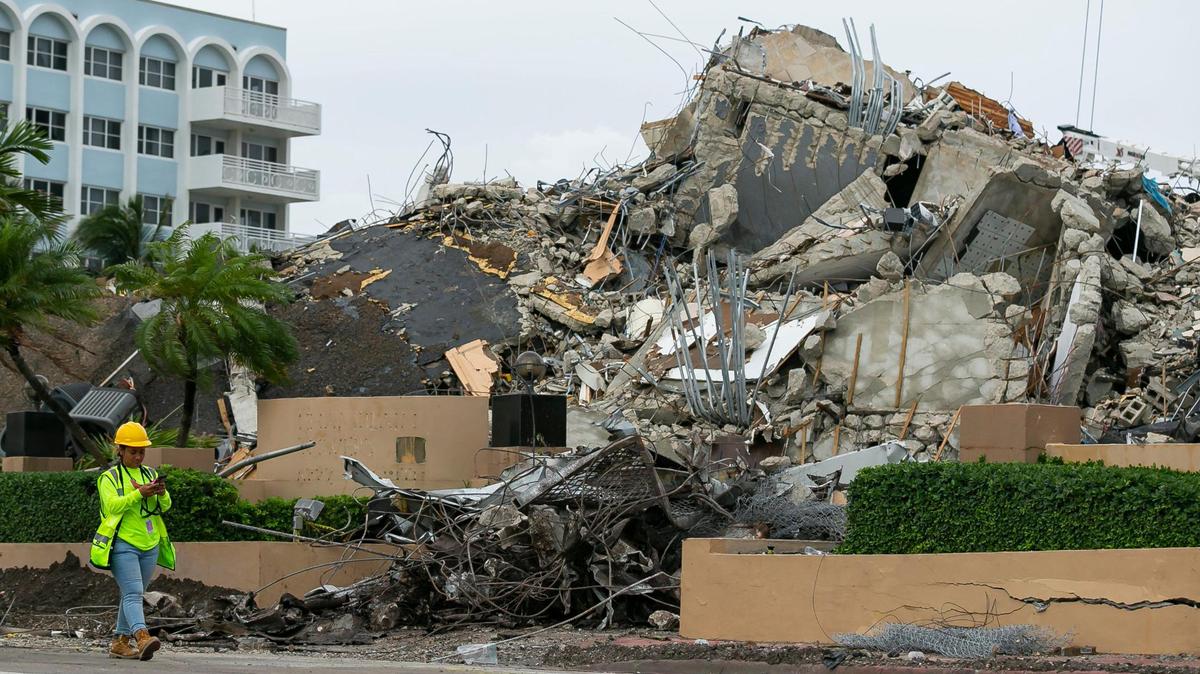 A workers make her way past the rubble and debris of the Champlain Towers South condo in Surfside, Florida on Tuesday, July 6, 2021. The rubble shown here is from the front portion of the condo towers, which was demolished 11 days after the back part of the tower collapsed with people inside.
