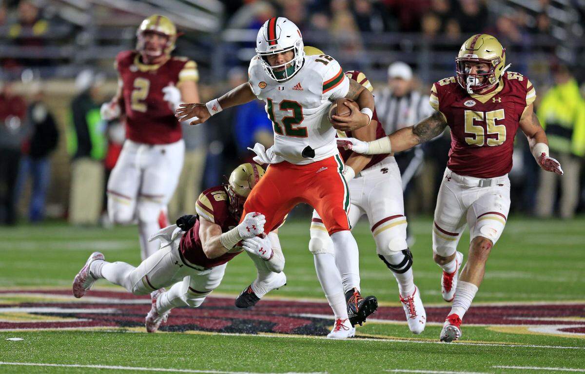 Miami Hurricanes quarterback Malik Rosier (12) runs for a first down in the second quarter as the University of Miami plays Boston College at Alumni Stadium in Chestnut Hill on Friday, October 26, 2018.