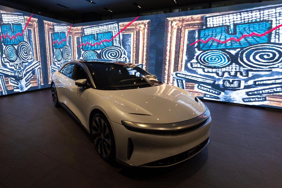 A Lucid Air Grand Touring model surrounded by animated artwork at the Brickell Studio showroom for Lucid, a new high-end electric car company, within Brickell City Centre in Miami, Florida, on Friday, December 2, 2022.