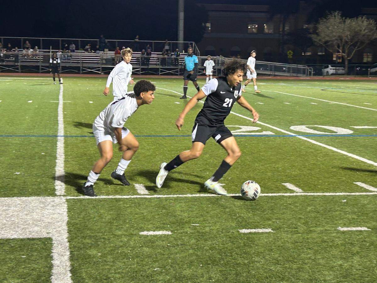 Pembroke Pines Charter’s Matthew Camacho dribbles away from a defender during Wednesday’s Region 4-5A final at home against Reagan High.