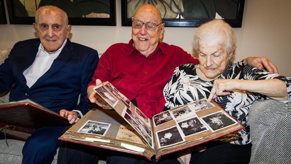 From left to right, Lewis Elias, 98, George Elias Jr., 97 and Virginia Elias, 101, look through family scrapbooks at Virginia’s house on Saturday, August 3, 2024 in Coral Gables, Fla.