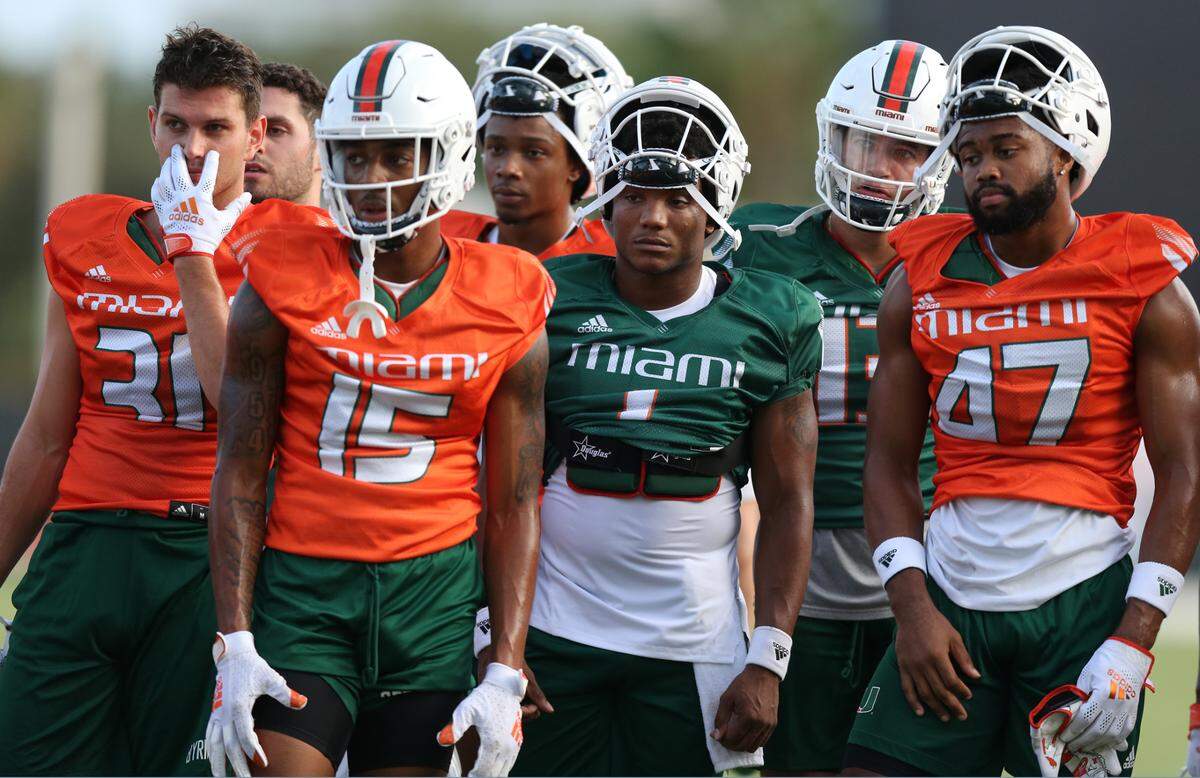Miami Hurricanes wide receiver Jacolby George (15) quarterback D’Eriq King (1) and Miami Hurricanes wide receiver Mykel Tubbs (47) join teammates during practice at the University of Miami’s Greentree Practice Field in Coral Gables on Saturday, August 7, 2021.