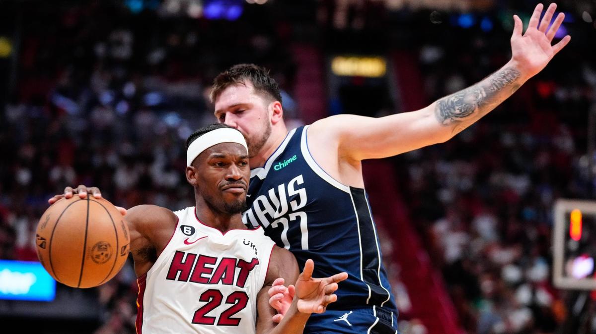 Miami Heat forward Jimmy Butler (22) dribbles the ball past Dallas Mavericks guard Luka Doncic (77) during the second quarter at Miami-Dade Arena.