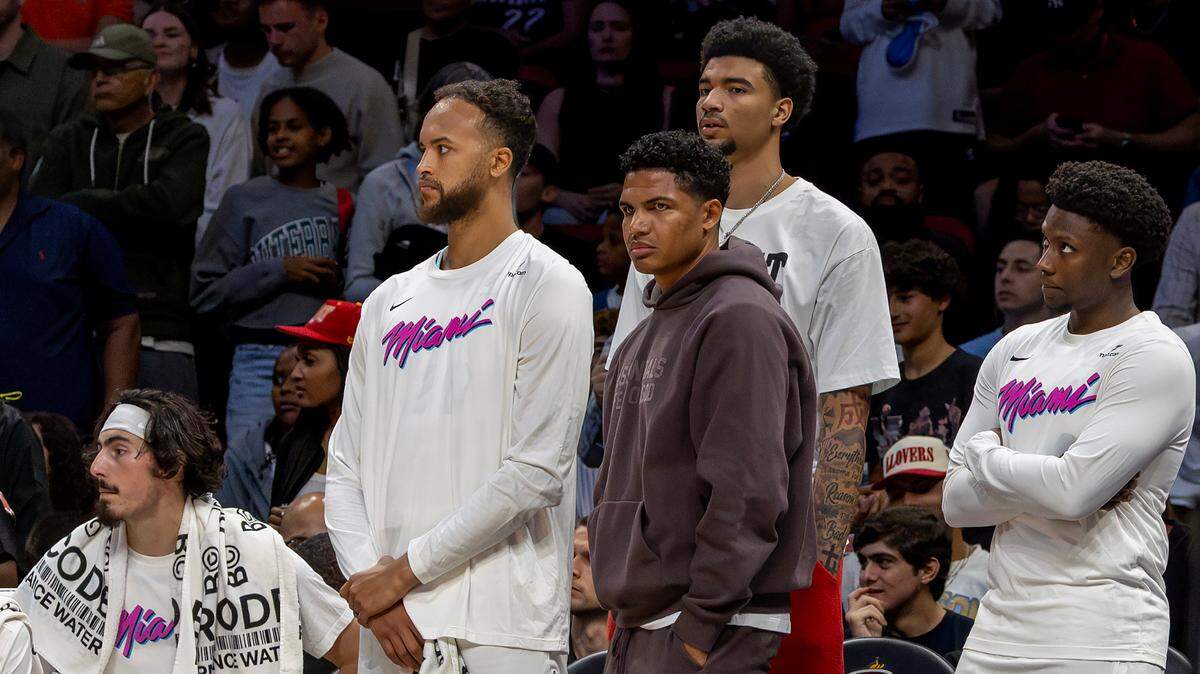 Miami Heat players Jaime Jaquez Jr. (11), Kyle Anderson (20), Dru Smith (12), Kel’el Ware (7), and Isaiah Stevens (4) watch from the bench during the second half of their NBA game against the Minnesota Timberwolves at Kaseya Center on Friday, March 7, 2025, in Miami.