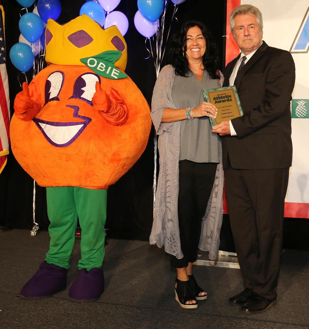 Lisa Zielinski of St. Thomas Aquinas is presented the 2018-2019 Female Sports Coach of the Year award by Miami Herald high school sports reporter Bill Daley during the Miami Herald Athletic Awards All-Broward banquet, Tuesday, May 21, 2019 at the Signature Grand in Davie.