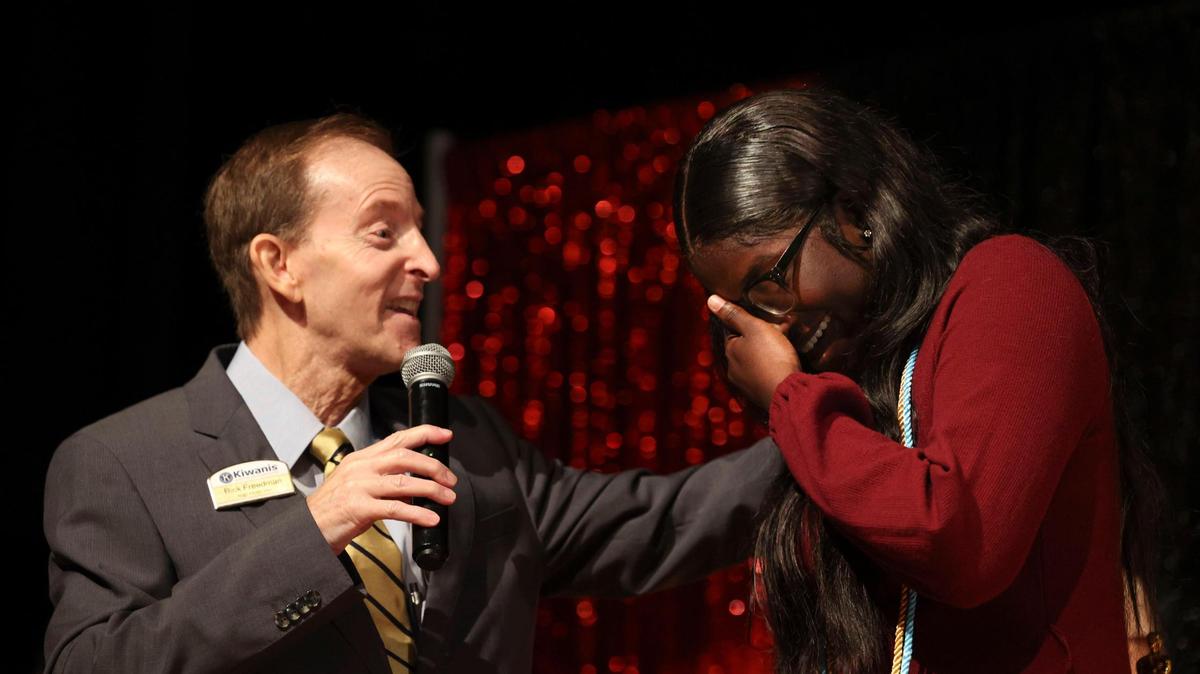 Rick Freedman, presidente del programa de becas del Biscayne Bay Kiwanis Club, le dice a Azorea McGill, alumna del último año de la preparatoria Booker T. Washington en Overtown, que es la beneficiaria de una beca de $30,000 del Club Kiwanis durante la ceremonia de entrega de premios a los estudiantes, el 24 de mayo de 2022.