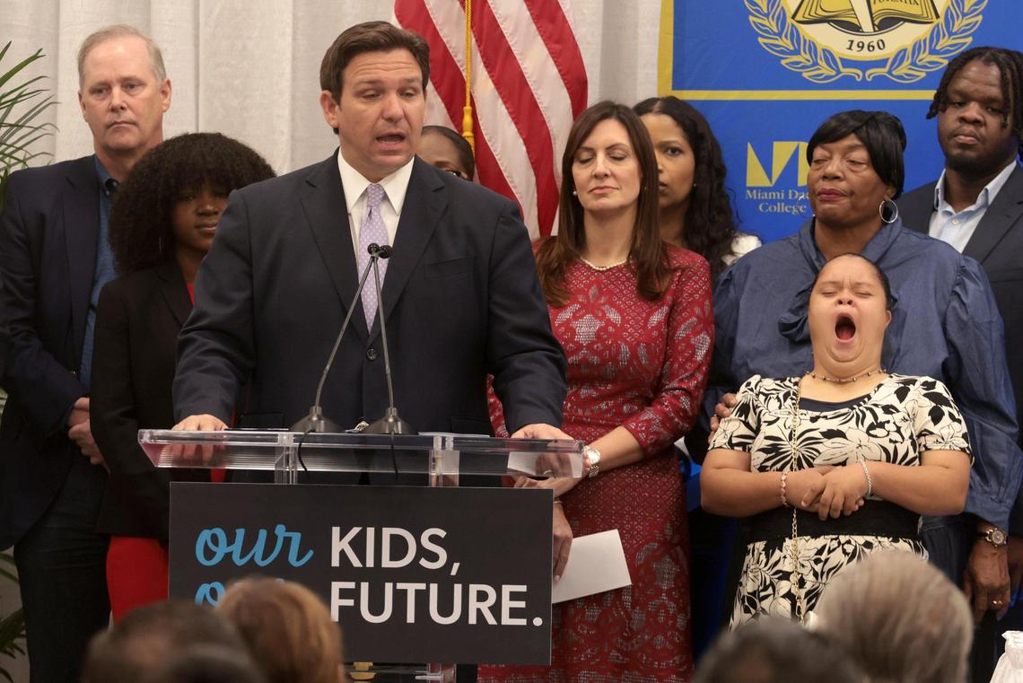 On Tuesday, April 12, 2022, Gov. Ron DeSantis, left, gives his opening remarks before he signed a bill that financially benefits more people who care for needy children and helps additional children who were in the foster care system attend a state college or university. The bill signing was at Miami Dade College Wolfson Campus in Miami, Florida.