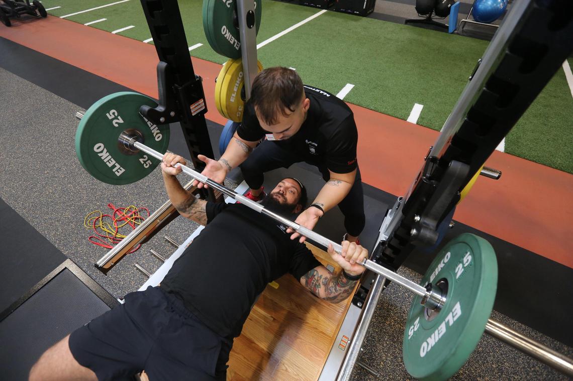 24 Hour Fitness Master Trainer, Orlando Lopez, guides Jessie Rodriguez, a Fitness Manager, through a barbell bench press as the two demonstrate the exercise at the fitness center at 1970 NW 117th Pl. in Miami on January 31, 2020.