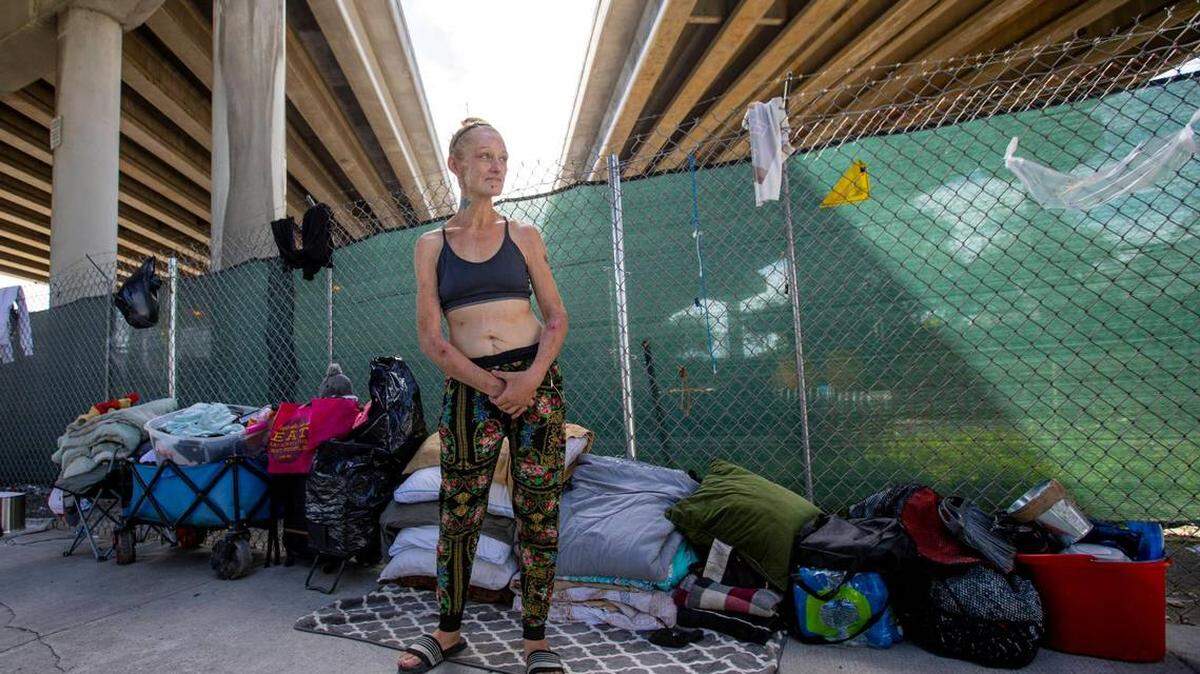 Bambi Nicole Kuttkuhn, who is homeless, stands underneath the I-95 expressway off Northwest 11th Street in Miami.