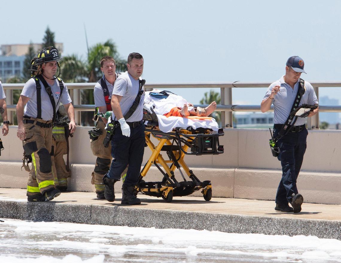 Miami-Dade rescue crews transport an injured patient after a plane hit the Haulover Bridge on Saturday.