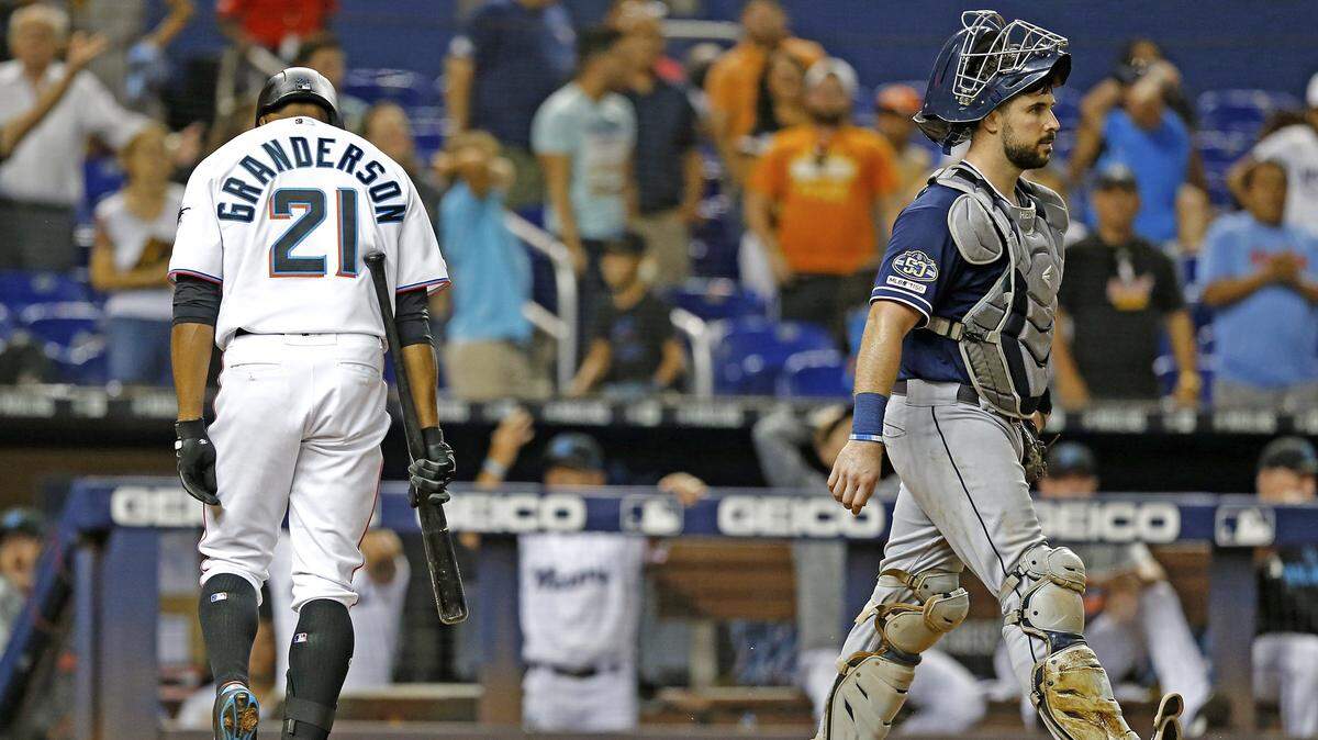 A dejected Miami Marlins left fielder Curtis Granderson (21) walks away from the plate after striking out while San Diego Padres catcher Austin Hedges (18) walks towards the closing pitcher to end the game in the ninth as the Miami Marlins play the San Diego Padres at Marlins Park on Wednesday, July 17, 2019.