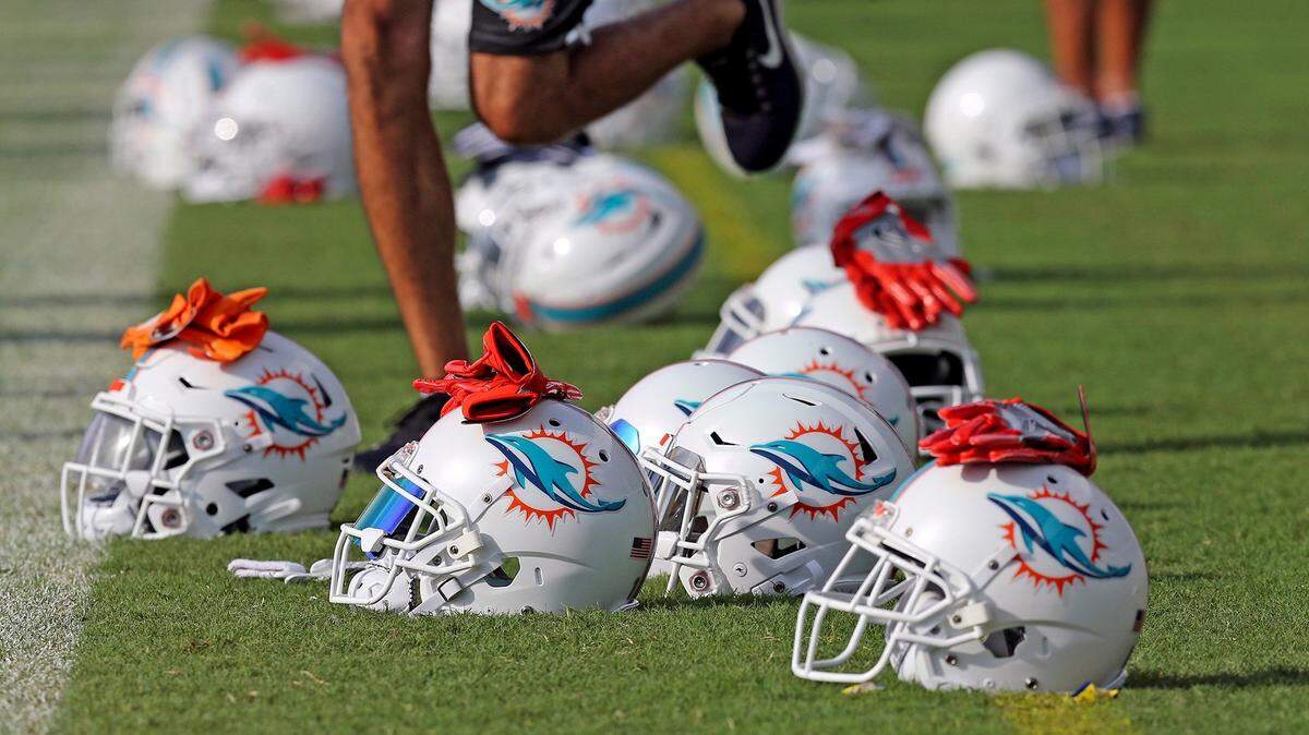 Miami Dolphins player’s helmets on the field as they warm-up during training camp at the Miami Dolphins facility in Davie, Florida, July 27, 2018.