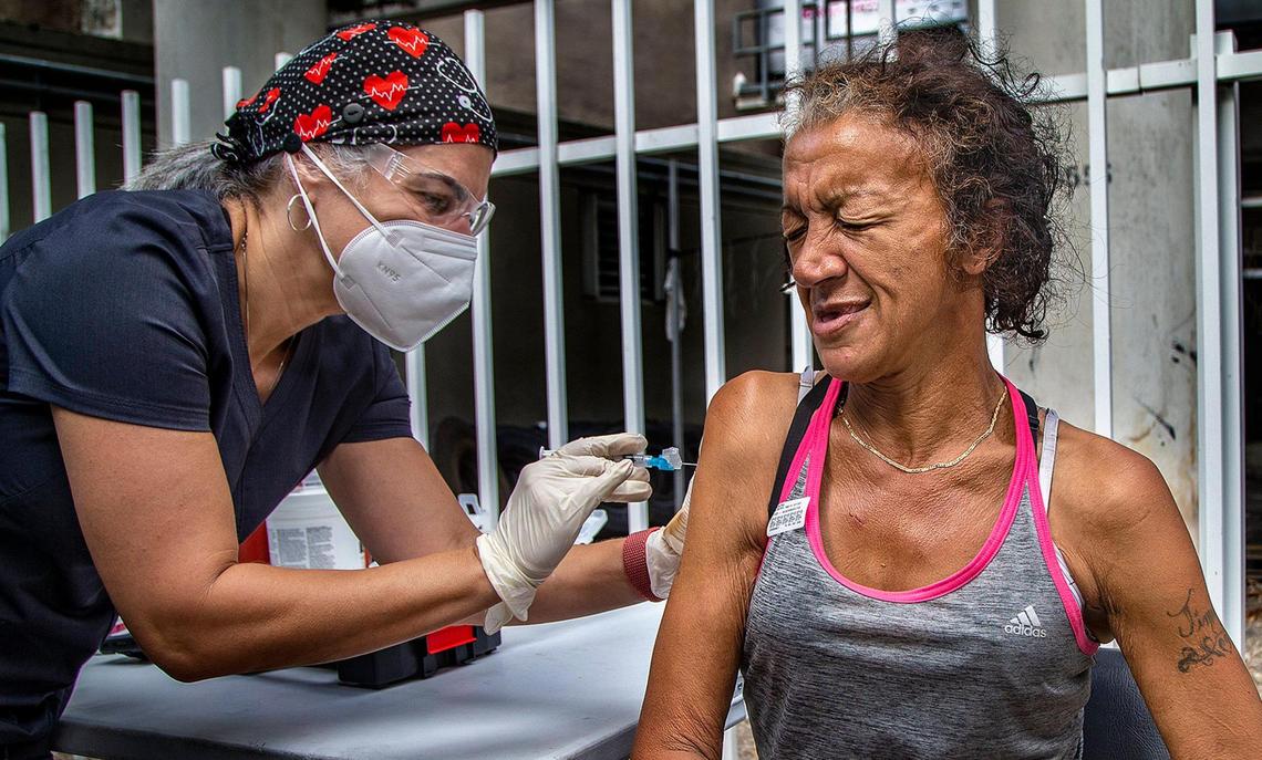 Nurse Niurka Pérez gives a shot of the (J&J/Janssen) COVID-19 Vaccine to Catherine Ortiz, a homeless woman who is living under the I-95 underpass in downtown Miami.