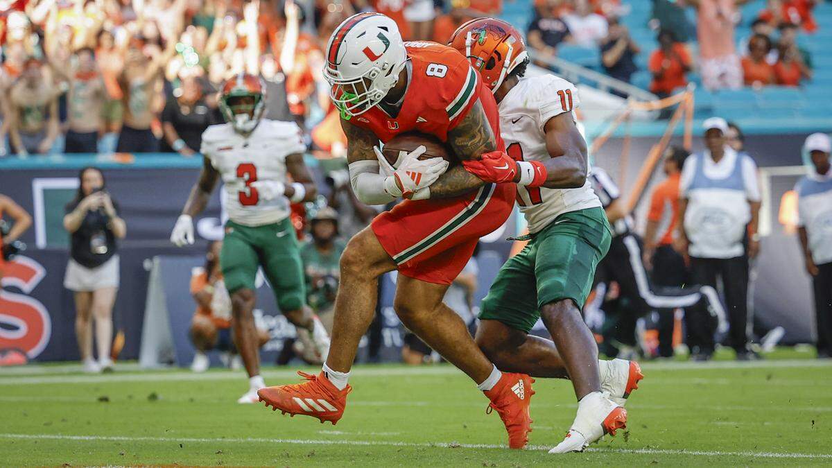 Miami Hurricanes tight end Elijah Arroyo (8) scores in the first half as Florida A&M Rattlers defensive back Deco Wilson (11) attempts to make the stop at Hard Rock Stadium in Miami Gardens, Florida, on Saturday, September 7, 2024.