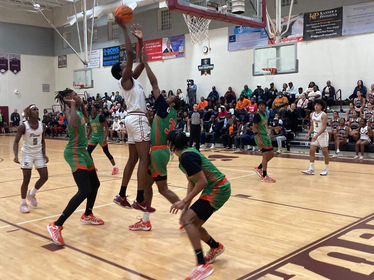 Pines Charter’s Robert Guishard puts up a shot over Blanche Ely’s Jayelen Jonas during Thursday night’s Region 4-5A final in the Pines Charter gym.