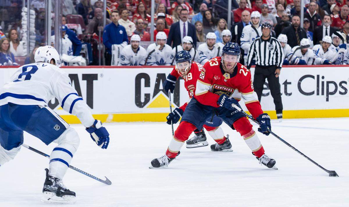 Florida Panthers center Carter Verhaeghe (23) skates with the puck as Toronto Maple Leafs defenseman Chris Tanev (8) defends in the first period of Game 6 of a second-round Stanley Cup playoffs series at the Amerant Bank Arena on Friday, May 16, 2025, in Sunrise, Fla.