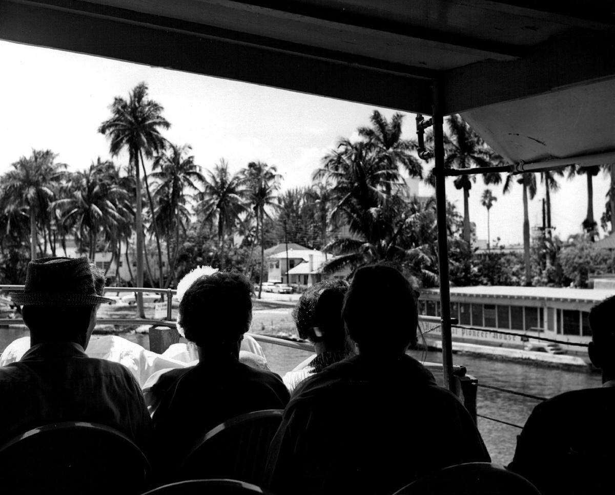 A sightseeing cruise makes its way up the Miami River.