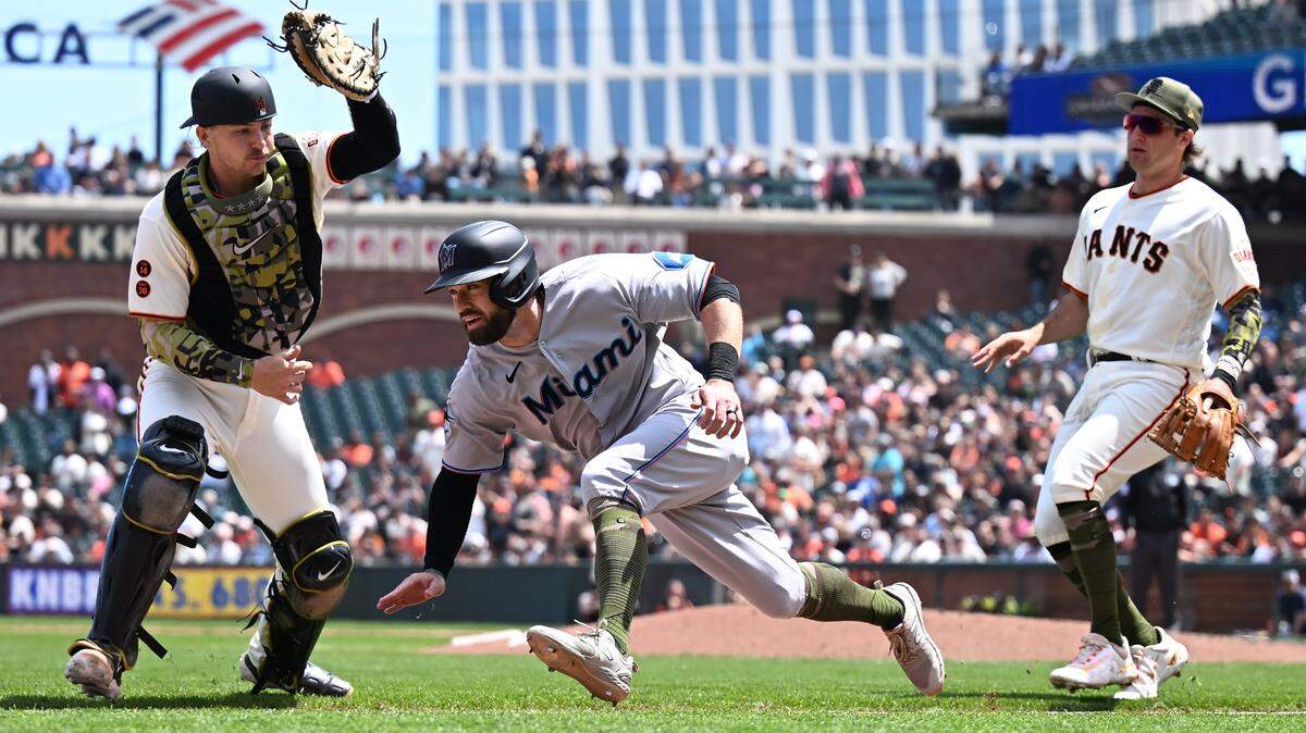 San Francisco Giants catcher Patrick Bailey (14) and infielder Casey Schmitt (6) chase Miami Marlins infielder Jon Berti (5) in a rundown play during the fifth inning at Oracle Park on Sunday, May 21, 2023.