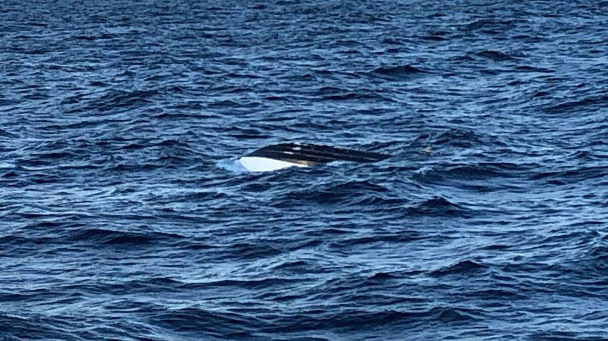 A Monday photo of the capsized 18-foot boat that once carried 11 people. The Coast Guard was able to rescue nine.