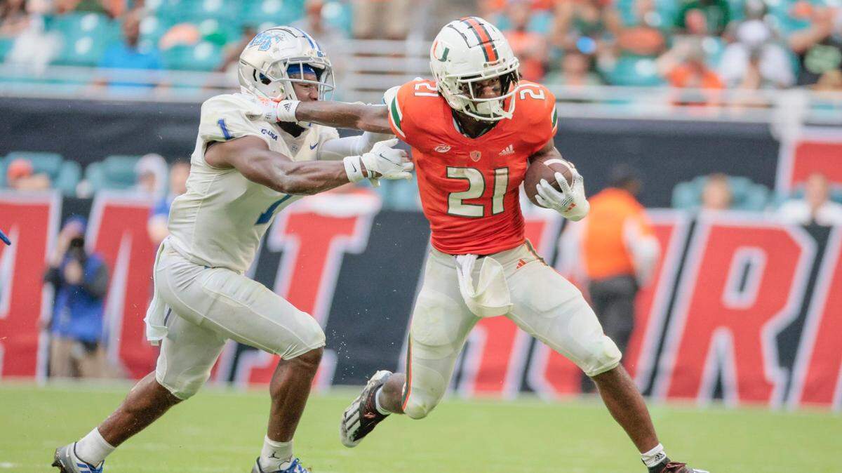 Miami Hurricanes running back Henry Parrish Jr. (21) runs for a first down as Middle Tennessee State Blue Raiders safety Teldrick Ross (1) defends in the second quarter at Hard Rock Stadium in Miami Gardens on Saturday, September 24, 2022.