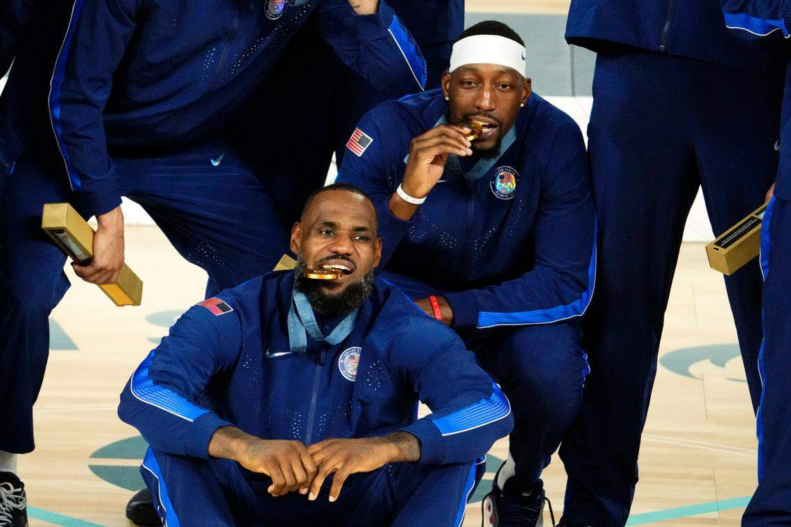 United States guard LeBron James (6) and center Bam Adebayo (13) celebrate with their gold medals after defeating France in the men’s basketball gold medal game during the Paris 2024 Olympic Summer Games at Accor Arena.