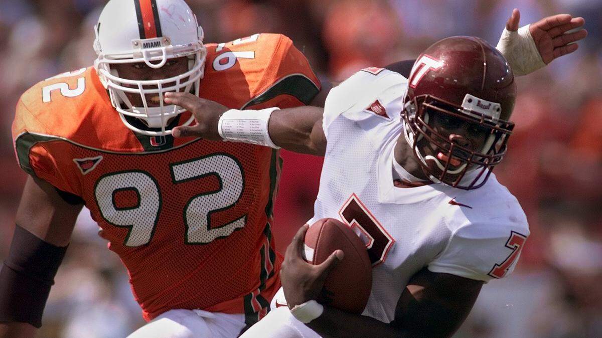 In this Nov. 4, 2000, file photo, University of Miami defensive lineman Damione Lewis chases Virginia Tech quarterback Michael Vick. Lewis is the Hurricanes’ new defensive tackles coach.