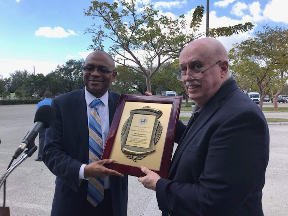 Retired Miami-Dade Circuit Judge Thomas K. Petersen receives The Alternative Programs’ Lifetime Achievement Award from program Executive Director Kenneth M. Kilpatrick at the Georgia Jones-Ayers Way street co-designation unveiling.