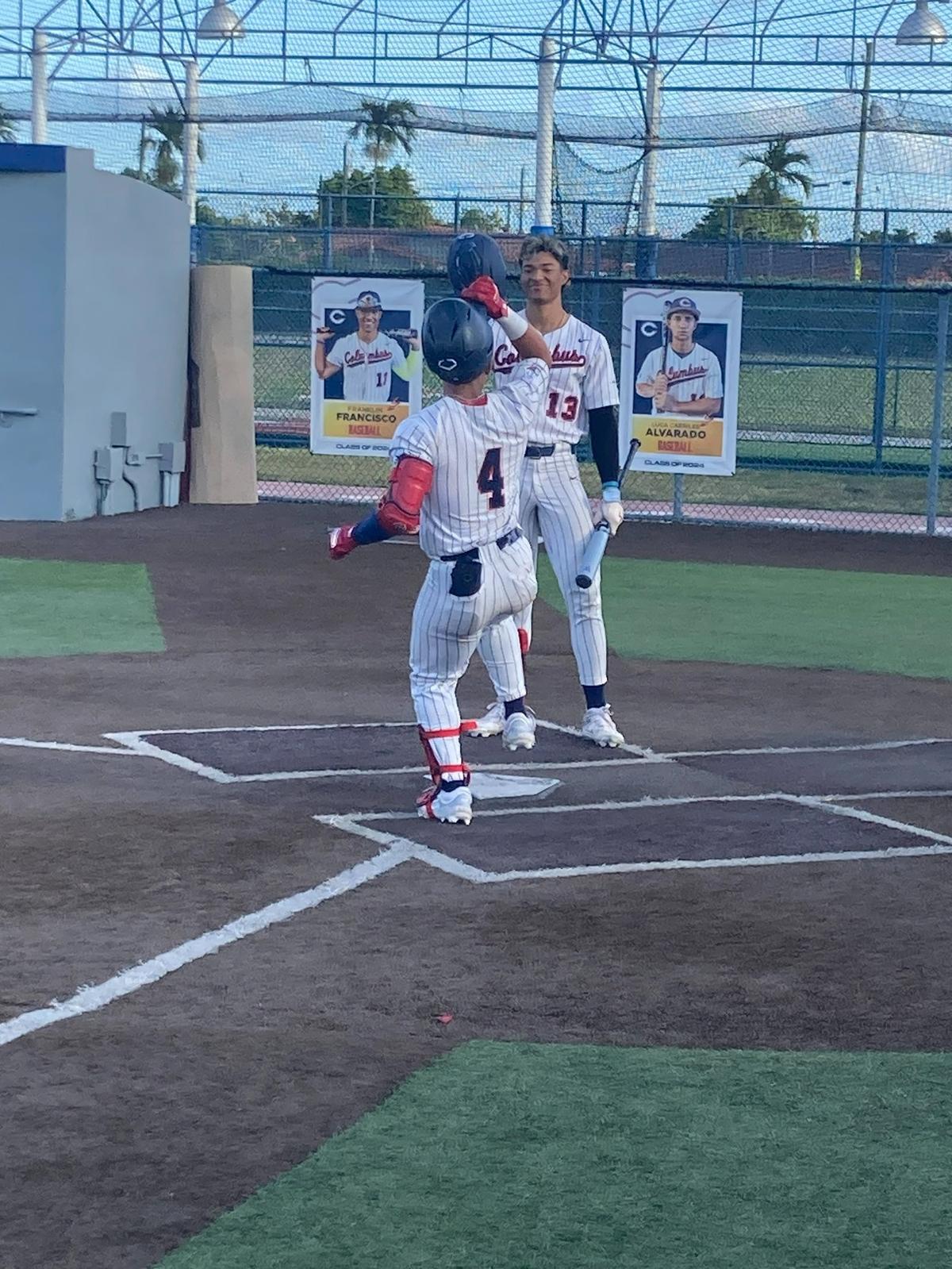 Columbus’ Zahir Barjam is congratulated by teammate Franklin Francisco after his early home run in Tuesday night’s GMAC baseball semifinal against Miami Springs.