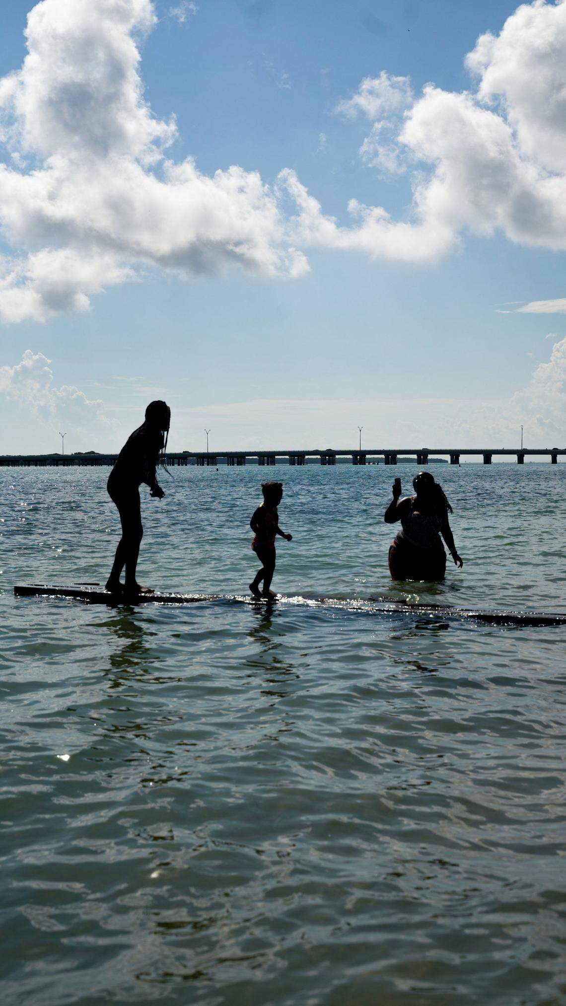 People enjoy the surf after the reenactment of the 1945 ‘wade-in’ in November that led to the creation of Virginia Key Beach Park in Miami.