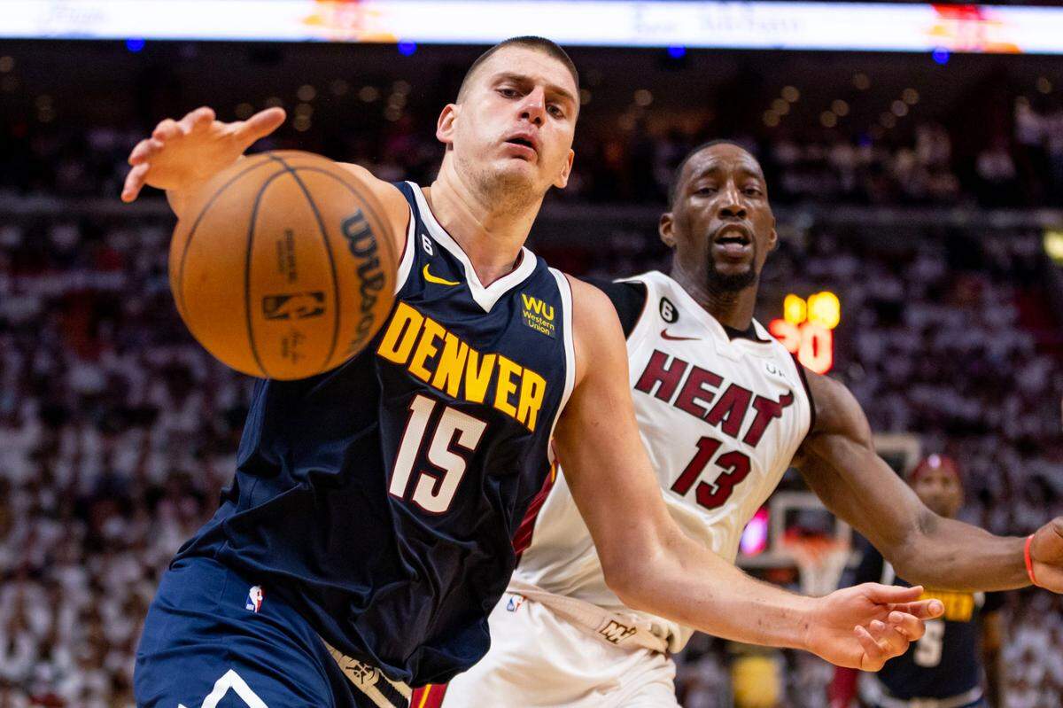Denver Nuggets center Nikola Jokic (15) controls the ball while driving on Miami Heat center Bam Adebayo (13) during the first half of Game 4 of the NBA Finals at the Kaseya Center on Friday, June 9, 2023, in downtown Miami, Fla.