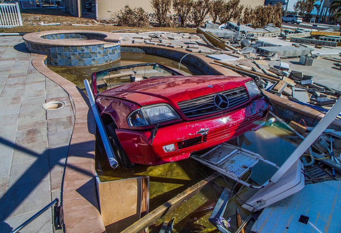 The front of a Mercedes Benz convertible sticks out of a pool in the backyard of a home on Estero Boulevard Wednesday, Oct. 26, 2022. The car ended up in the pool after Hurricane Ian slammed into the area as a Category 4 storm Wednesday, Sept. 28, 2022.