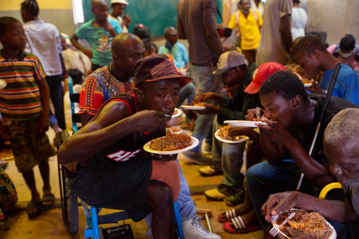 Displaced Haitians eat in a shelter for refugees on Thursday, June 24, 2021, a week after armed gangs set their homes on fire in Port-au-Prince, Haiti. Insecurity continues throughout the country, with Port-au-Prince being the most affected.