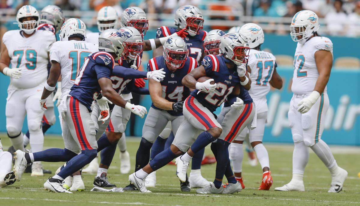 New England Patriots safety Jaylinn Hawkins (21) intercepts a pass from Miami Dolphins quarterback Tua Tagovailoa (1) in the first half of an NFL football game at Hard Rock Stadium in Miami Gardens, Florida, on Sunday, September 14, 2025.