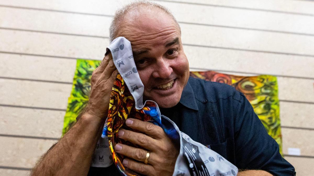 Miami-Dade artist-in-residence Xavier Cortada uses his newly designed cooling towel he created in partnership with Mission to celebrate the launch of the #KeepCoolMiamiDade extreme heat awareness campaign at Coral Gables Museum on Thursday, May 25, 2023.