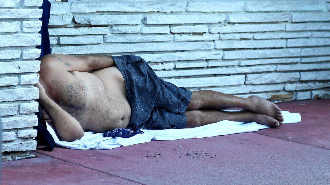A homeless man sleeps on the sidewalk on Pennsylvania Avenue and Lincoln Road in Miami Beach in August 2020.